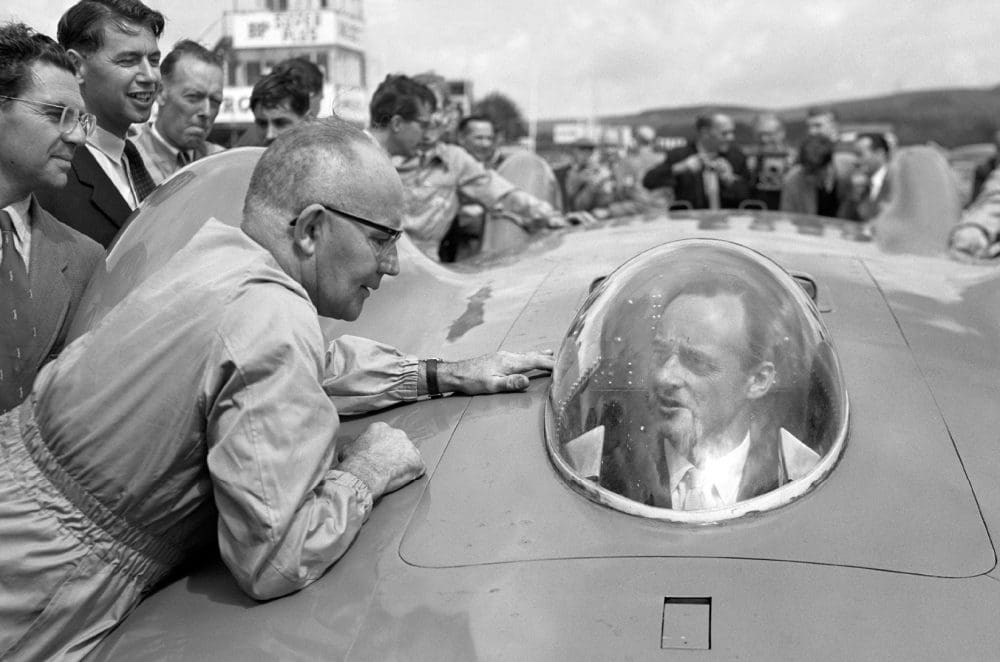 Leo Villa talks to Donald Campbell, seated at the wheel of his Bluebird car, 1960.